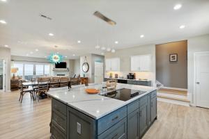 a kitchen and living room with a large island in the middle at BeachZilla - 907 East Arctic in Folly Beach