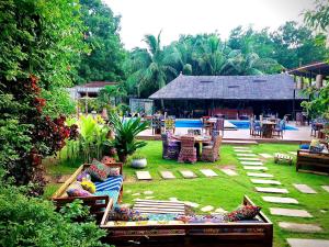 um jardim com uma mesa e cadeiras e um edifício em Le Patio em Lomé