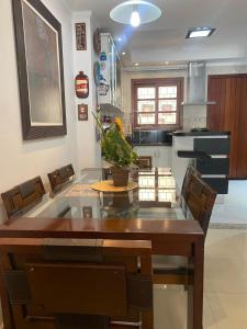 a dining room with a table and chairs and a kitchen at Triplex c/ hidro 15 min do Praia de Belas e Barra Shopping in Porto Alegre