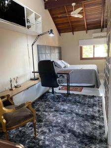 um quarto com uma cama, uma secretária e uma cadeira em Triplex c/ hidro 15 min do Praia de Belas e Barra Shopping em Porto Alegre