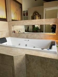 a large white bath tub in a bathroom at Triplex c/ hidro 15 min do Praia de Belas e Barra Shopping in Porto Alegre