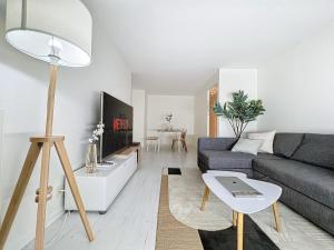 ein Wohnzimmer mit einem Sofa und einem Tisch in der Unterkunft Chaleureux et spacieux - Paris - Stade de France in Saint-Denis