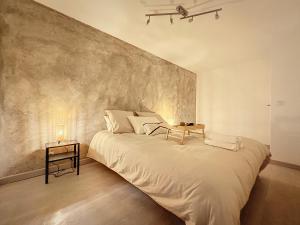 a large white bed in a room with a wall at Chaleureux et spacieux - Paris - Stade de France in Saint-Denis