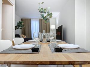 - une table à manger avec des assiettes blanches et des verres à vin dans l'établissement Chaleureux et spacieux - Paris - Stade de France, à Saint-Denis