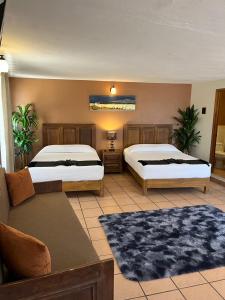 sypialnia z 2 łóżkami i kanapą w obiekcie Hotel Jardín del Cantador w mieście Guanajuato