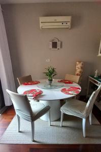 una mesa blanca y sillas en la sala de estar. en Apartamento 2 quartos aconchegante en Santos