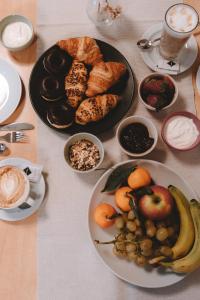 einen Tisch mit Teller mit Lebensmitteln und Schalen mit Früchten in der Unterkunft Anewandterhof in Bruneck