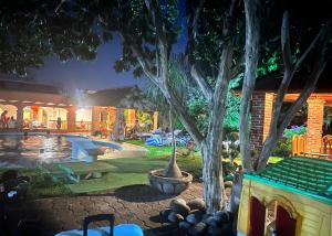 un patio trasero con piscina y una casa en Hotel Posada Andaluz en Xochitepec