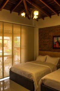 a bedroom with two beds and a window at Santa bárbara in Santa Rosa de Cabal