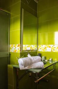 a green bathroom with a glass sink and towels at Santa bárbara in Santa Rosa de Cabal