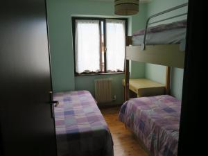 1 Schlafzimmer mit 2 Etagenbetten und einem Fenster in der Unterkunft Carè Alto in Carisolo