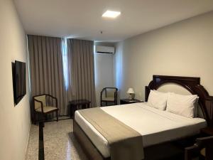 Américas Benidorm Hotel في ريو دي جانيرو: غرفه فندقيه بسرير وكرسيين