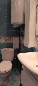 a bathroom with a white toilet and a sink at Europroperties Zlatna Kotva Apartments in Golden Sands