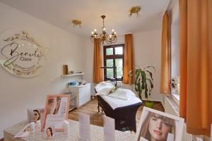 ein Wellnesszimmer mit einem Bett und Bildern auf einem Tisch in der Unterkunft Gasthof und Pension Hammerschänke in Wildenthal