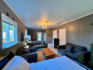 a living room with two couches and a table at The Spruce Cape Collective - 5 Bed - House with Fireplace in Kodiak