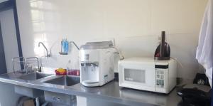 a kitchen counter with a coffee maker and a microwave at A3EM Casa de Gorceix in Ouro Preto