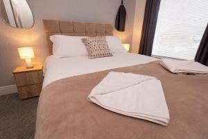 um quarto com uma cama com um cobertor branco em Suggitt House em Hartlepool