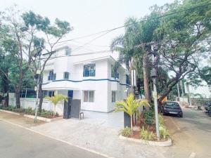 un edificio blanco con palmeras frente a una calle en Bay Breeze Suites, en Chennai