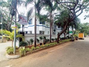 un edificio con palmeras al lado de una calle en Bay Breeze Suites, en Chennai