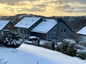 une maison avec de la neige sur le toit dans l'établissement Sperrentalblick, à Sankt-Andreasberg