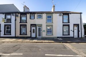 a white house with white doors on a street at The bay cottage hot tub in Morecambe