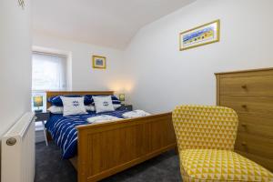 a bedroom with a bed and a yellow chair at The bay cottage hot tub in Morecambe