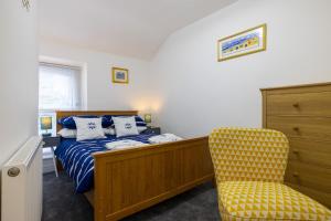 una camera da letto con un letto e una sedia gialla di The Bay Cottage Hot Tub & Sauna Morecambe Bay a Morecambe