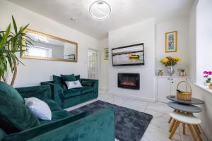 a living room with a green couch and a fireplace at The bay cottage hot tub in Morecambe
