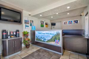 una sala de espera en un hotel con TV de pantalla grande en Motel 6 Santa Fe, en Santa Fe