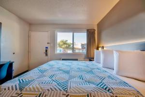 a bedroom with a large bed with a window at Motel 6 Santa Fe in Santa Fe