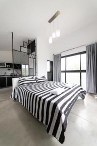 sypialnia z czarno-białym łóżkiem o paskach w obiekcie El Refugio Apart w mieście Villa Serranita