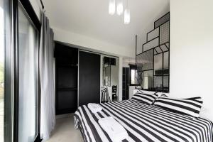1 dormitorio con cama de rayas en blanco y negro en El Refugio Apart en Villa Serranita