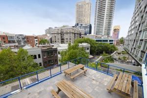a balcony with benches and a view of a city at Trademark Hostel Sydney in Sydney