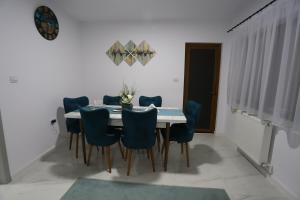 jadalnia ze stołem i niebieskimi krzesłami w obiekcie Private house w mieście Vaslui