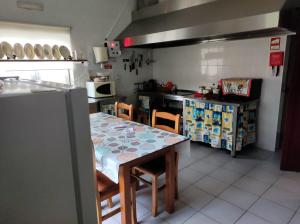 cocina con mesa, sillas y barra en Casa do Lago, en Vila de Rei