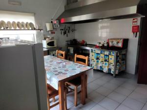 a kitchen with a table and chairs and a counter at Casa do Lago in Vila de Rei