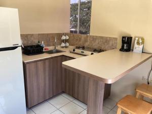 uma cozinha com um balcão, um lavatório e um frigorífico em Oranjestad Apartment em Oranjestad
