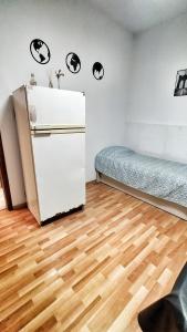 Zimmer mit einem Kühlschrank und einem Bett. in der Unterkunft Lavalle III in Venado Tuerto