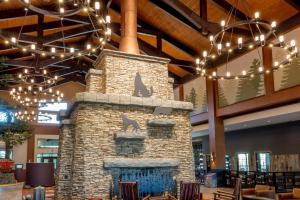 a stone fireplace in a lobby with chandeliers at Great Wolf Lodge Georgia in La Grange