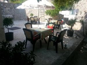 a group of tables and chairs with an umbrella at Apartments Debora in Ulcinj