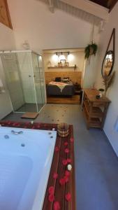 ein Badezimmer mit einer Badewanne und ein Schlafzimmer mit einem Bett in der Unterkunft Chalé Jasmim in Santo Antônio do Pinhal