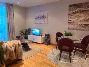 a living room with chairs and a table and a television at Modern Dublin City Centre in Dublin