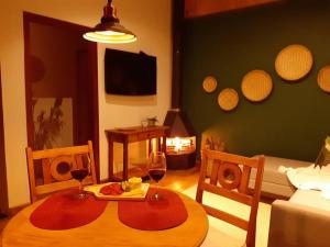 - un salon avec une table et deux verres de vin dans l'établissement Chalé Jasmim, à Santo Antônio do Pinhal