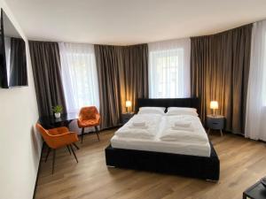 1 dormitorio con 1 cama grande y 1 silla en Hotel Elisei en Núremberg