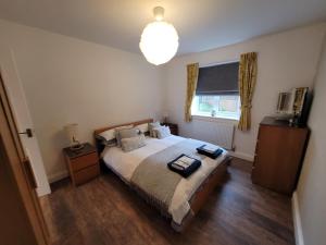 a bedroom with a bed and a window and a chandelier at BriValley View in High Bickington