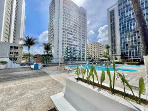 a swimming pool in a city with tall buildings at Condomínio em frente ao Rio Mar e ao lado da Praia em Fortaleza in Fortaleza