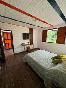 Schlafzimmer mit einem Bett, einem Fenster und einem Tisch in der Unterkunft Cabaña Quindiana - Excelente Ubicación in Montenegro