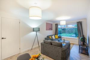 a living room with a couch and a table at Modern 4 Bed House-Free Parking in Uphall