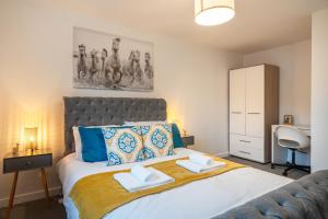 a bedroom with a bed with two towels on it at Modern 4 Bed House-Free Parking in Uphall