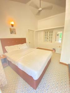 um quarto com uma grande cama branca num quarto em sea shore guest house morjim beach em Morjim